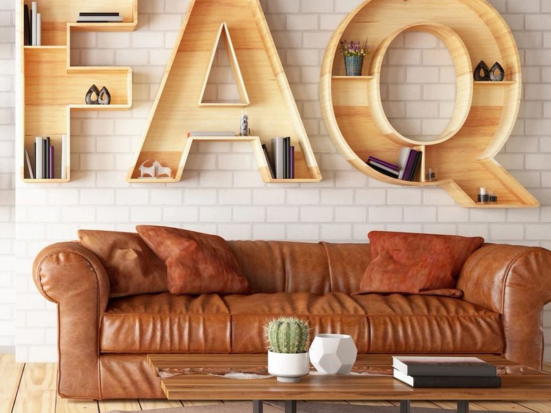 large wood letters spelling FAQ above a leather sofa